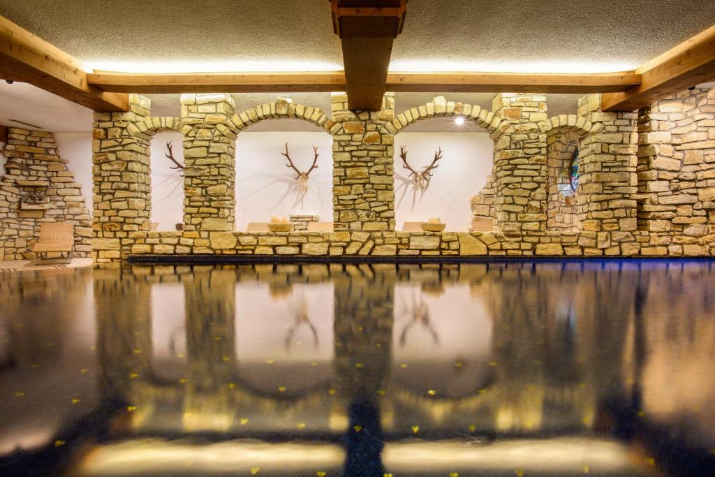 施伦斯阿卡缇弗阿尔彭罗斯温泉酒店的一间墙上挂有钟的石墙客房