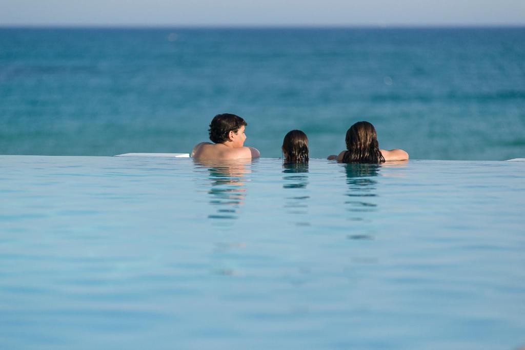哈马马特新巴达旅馆的三人在海洋里游泳