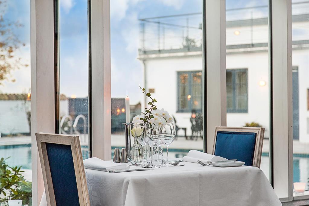 斯坎法尔斯特布盖斯林根酒店的一张桌子、白色的桌布、椅子和窗户