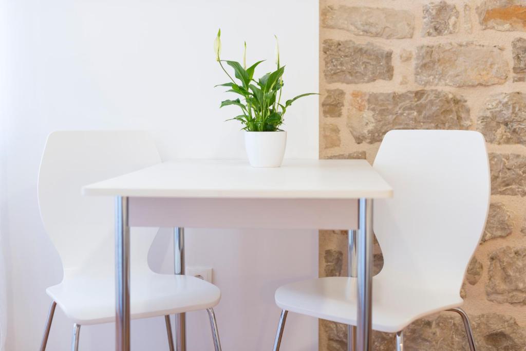 赫瓦尔赫瓦尔阿加塔家公寓的一张带两把白色椅子的白色桌子和植物
