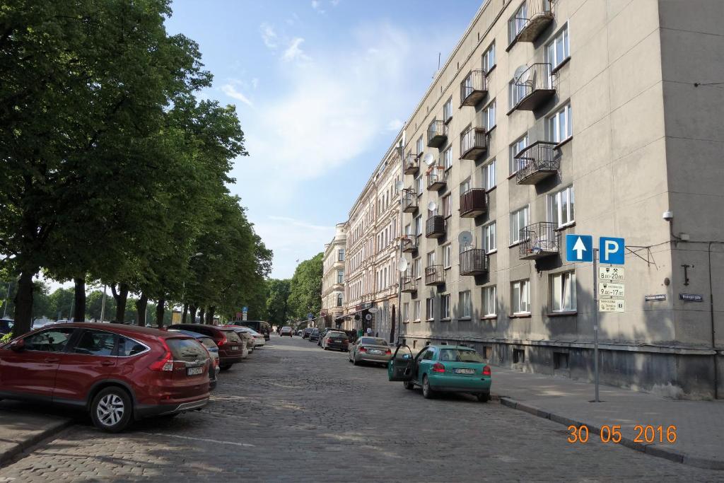 里加Apartment Old Town Riga River View的一条街道,汽车停在大楼的一侧