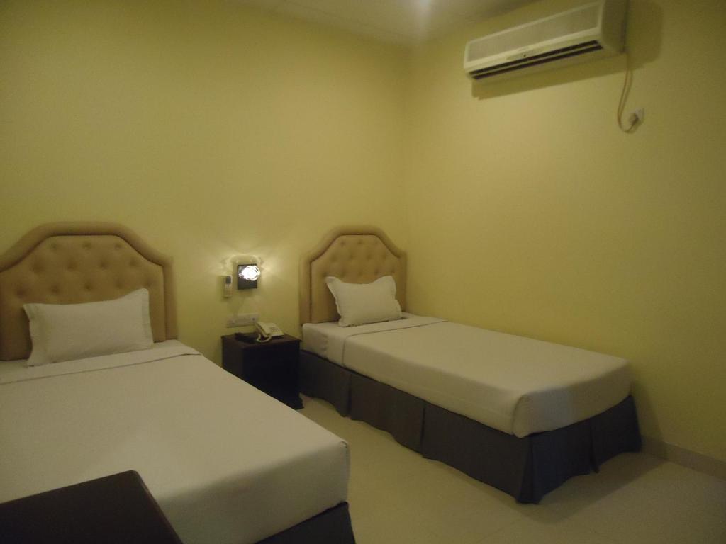 吉大港行政旅馆的一间设有两张床和空调的房间