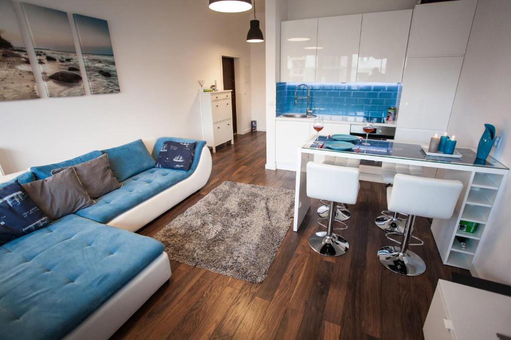 达洛科Apartament Nad Morzem的一间带蓝色沙发的客厅和一间厨房