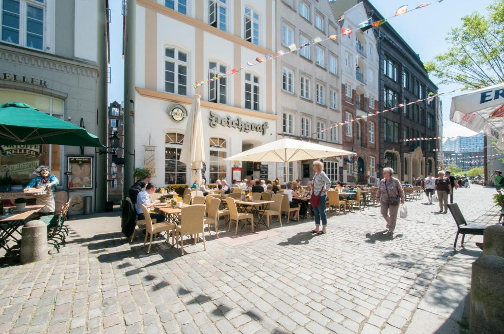 汉堡Appartements in der historischen Deichstrasse contactless Check in的坐在街上桌子上的一群人