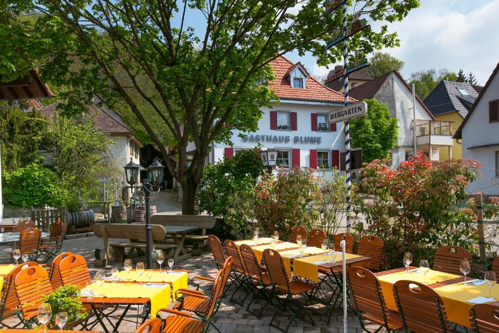 埃夫林根基兴Zur Blume Hotel & Restaurant Efringen-Kirchen bei Basel的户外餐厅设有黄色的桌椅
