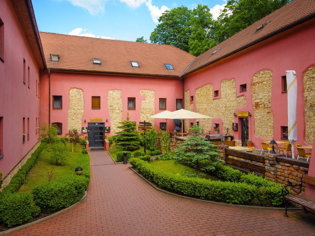布拉格斯塔利皮沃瓦尔酒店的粉红色建筑的庭院,带有庭院