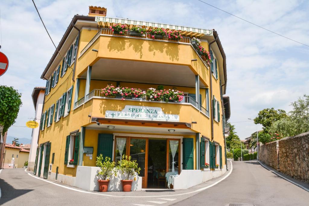 托里德尔贝纳科Locanda Speranza的黄色的建筑,花斑在建筑的一侧