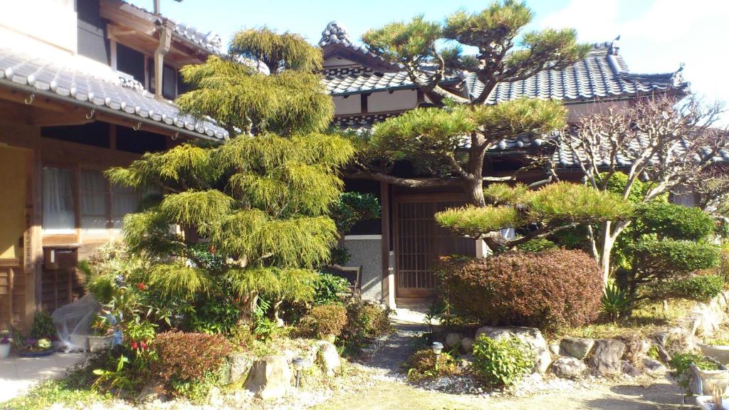 宇陀市尼西米纳住宿加早餐酒店的一座建筑前的松树