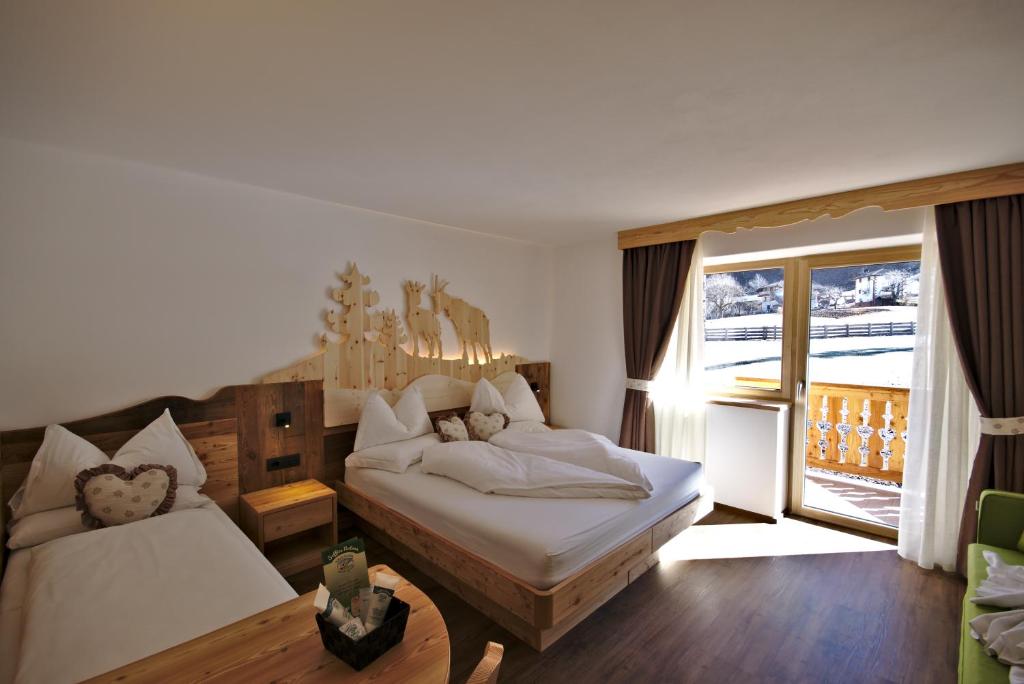 泰塞罗Agritur Maso Piasina的一间卧室设有两张床和大窗户