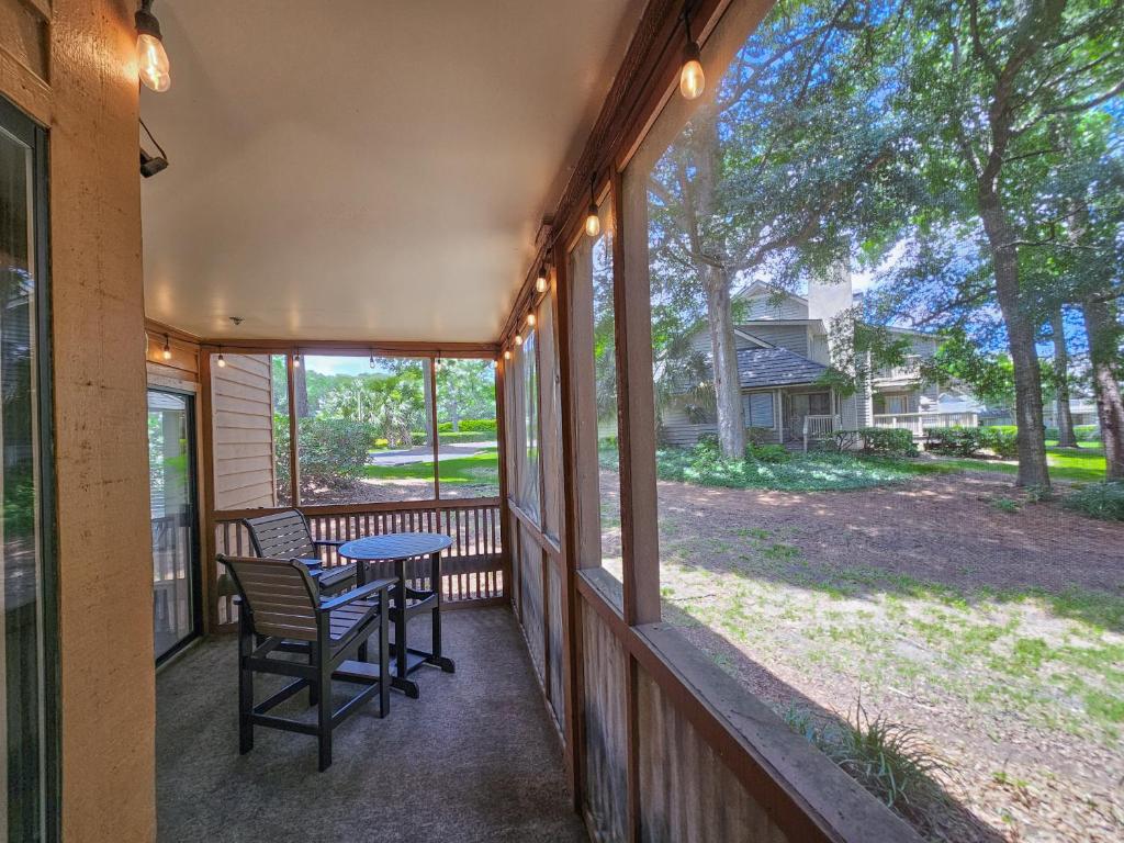 默特尔比奇Serene 2 bed, 2 bath lodge, with amenities, 101AC lodge的带纱窗的门廊，上面有桌子和椅子