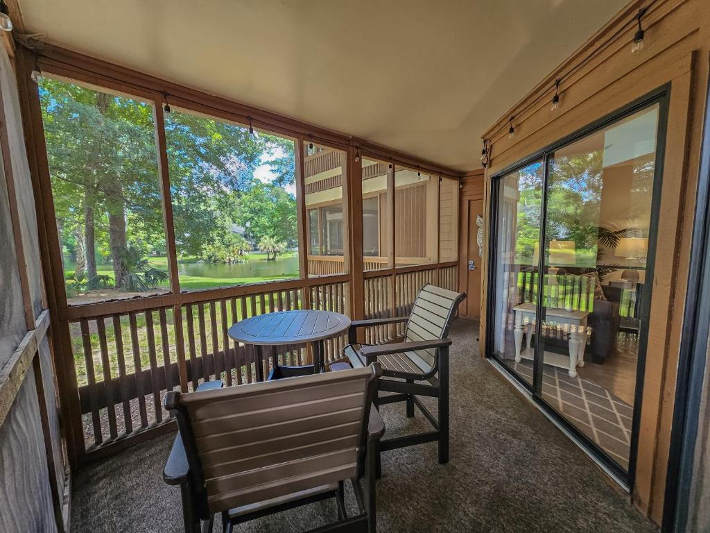 默特尔比奇Serene 2 bed, 2 bath lodge, with amenities, 101AC lodge的带桌椅的封闭式门廊