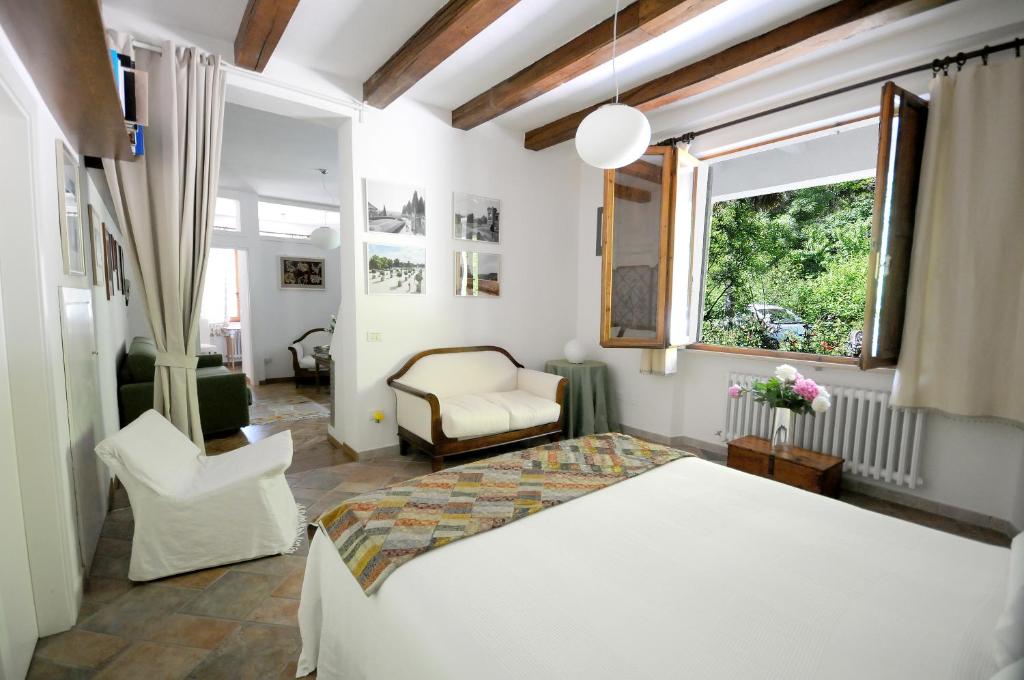 乌尔比诺Casa Disma Urbino的卧室配有床、椅子和窗户。