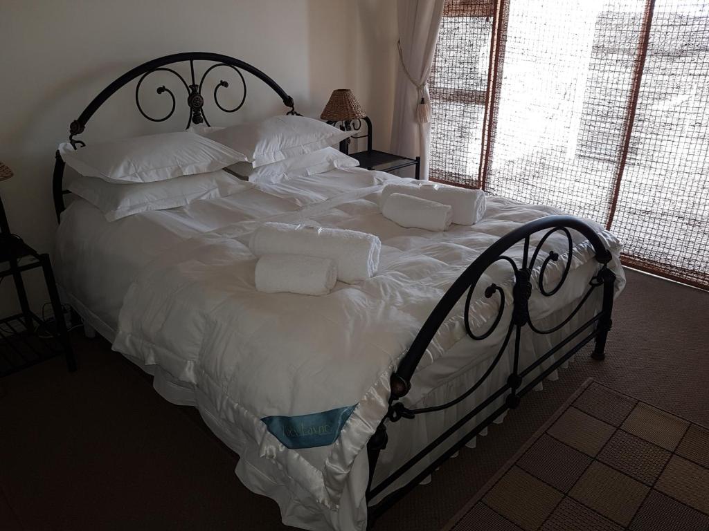 比格湾Bradclin Beach Blouberg的一张配有白色床单和枕头的大床