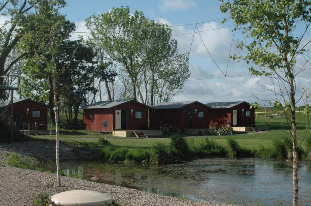 Sankt IbbNatursköna Gamlegård på Ön Ven的一群有河流和树木的建筑