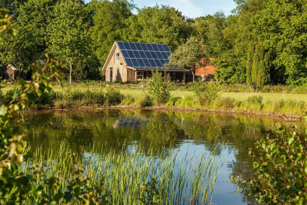 伊科斯特het Atelier的湖畔屋顶上设有太阳能电池板的房子