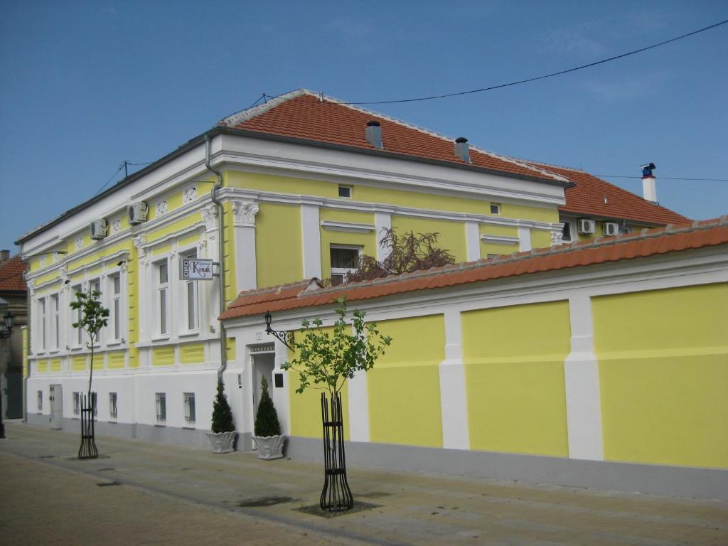 波扎雷瓦茨Konak的一座黄色和白色的建筑,前面有树木