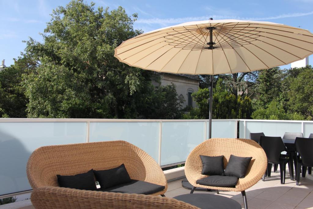 阿尔勒布朗希公寓的庭院配有两把椅子和一把遮阳伞