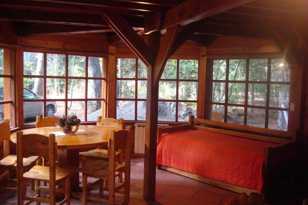 圣卡洛斯-德巴里洛切卡瓦尼亚斯卢塞罗博斯克山林小屋的卧室配有一张床和一张桌子及椅子