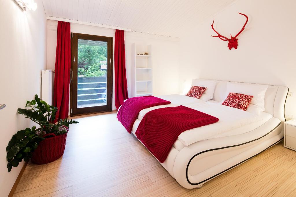 哈尔施塔特W & S行政公寓酒店 - 哈尔施塔特 I 号的配有红色窗帘的客房内的白色床