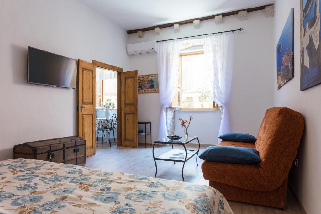 杜布罗夫尼克茹德尔公寓式酒店的一间卧室配有一张床、一把椅子和电视