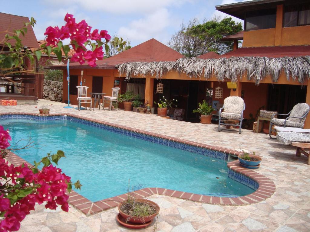 Santa Cruz火地岛米欧住宿加早餐旅馆的一座鲜花盛开的房子前的游泳池