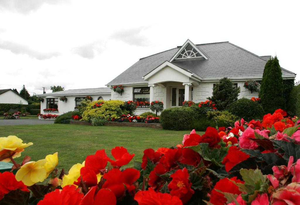 邓多克罗斯蒙特B＆B住宿加早餐酒店的院子里有红色和黄色花的房子