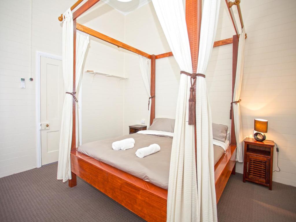麦凯中央商务区度假屋的一间卧室配有一张天蓬床和两个枕头