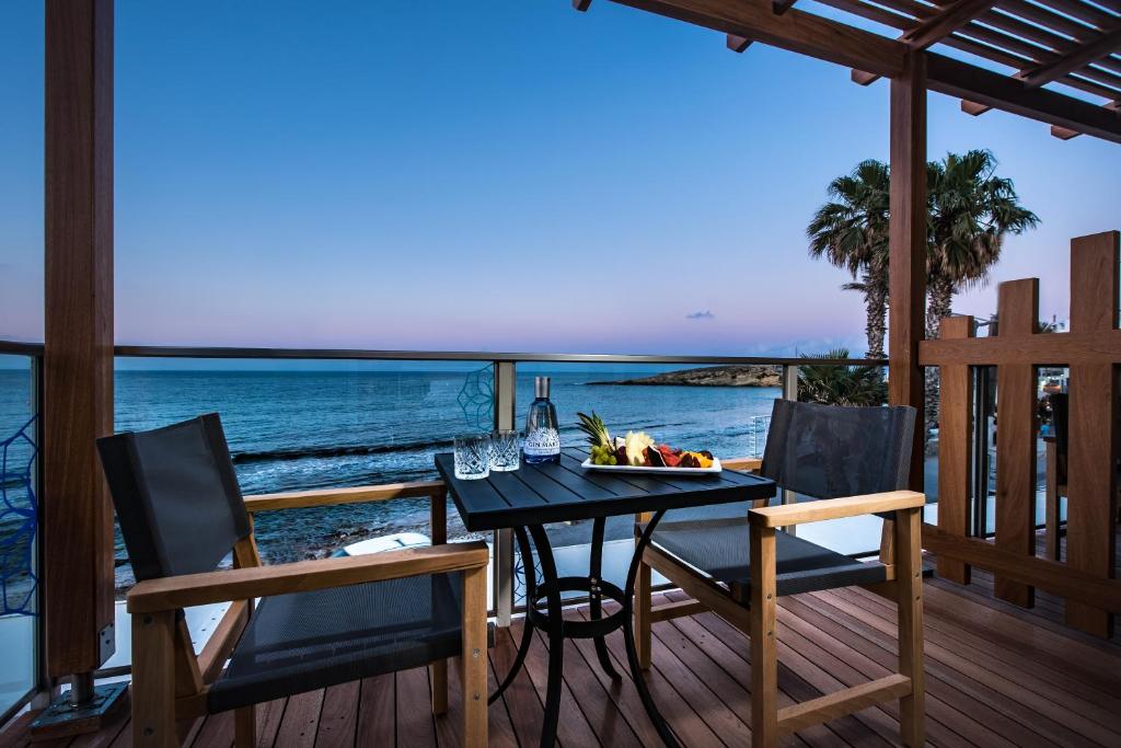 赫索尼索斯无限蓝精品酒店及Spa - 仅限成人的海景甲板上的餐桌和椅子