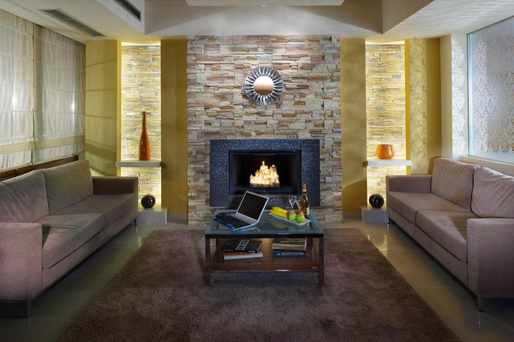 塞萨洛尼基佩弗卡酒店的客厅设有两张沙发和一个壁炉