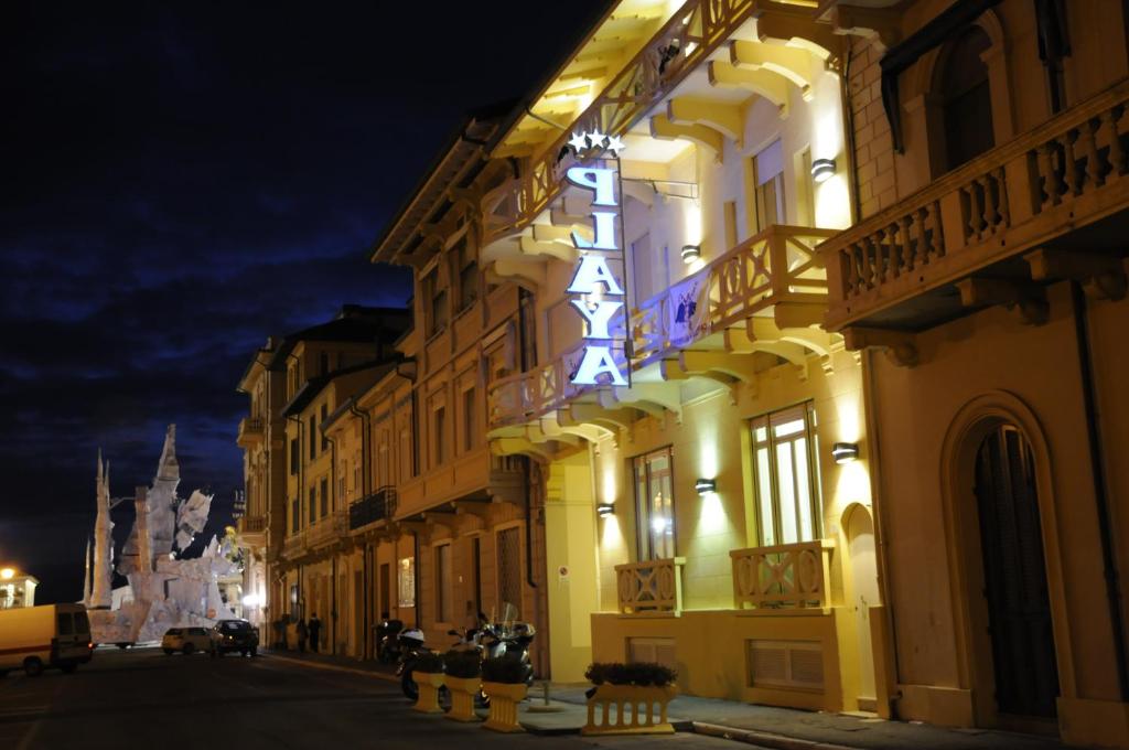 维亚雷焦普拉亚酒店的一座建筑物,晚上在建筑物的一侧有标志