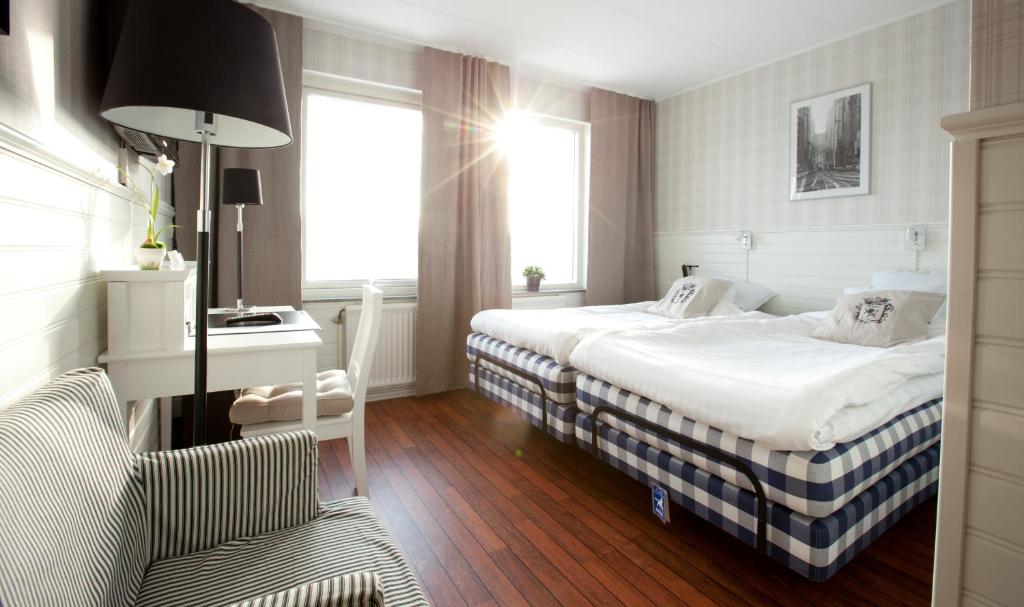 布罗斯拉格斯汽车旅馆的酒店客房 - 带两张床、一张桌子和一把椅子