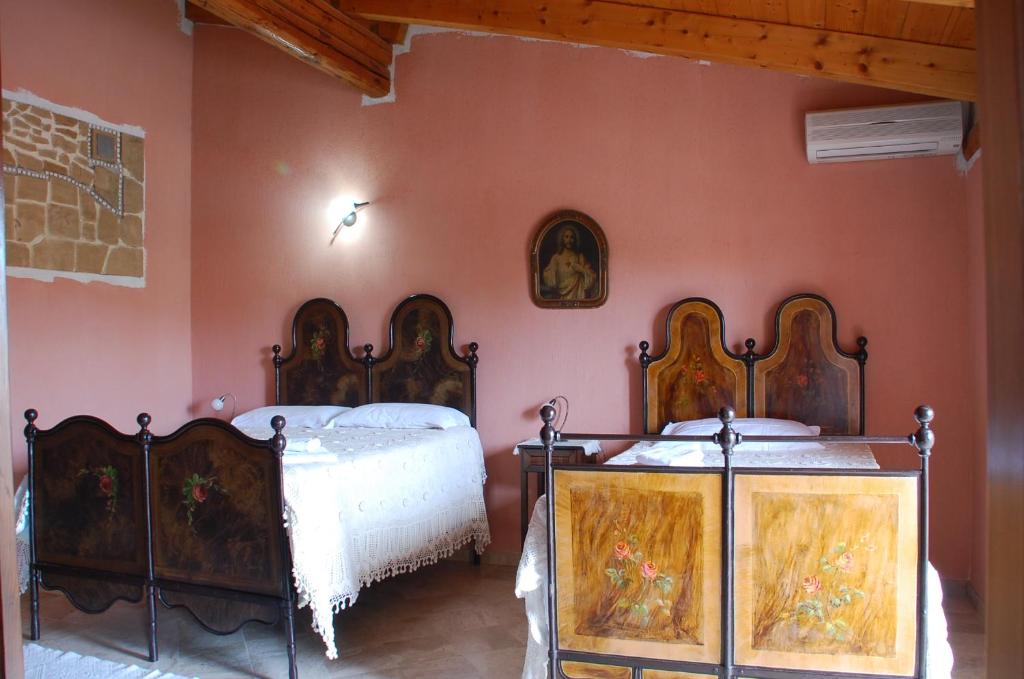卡布拉斯Sa Crannaccia的配有粉红色墙壁的客房内的两张床