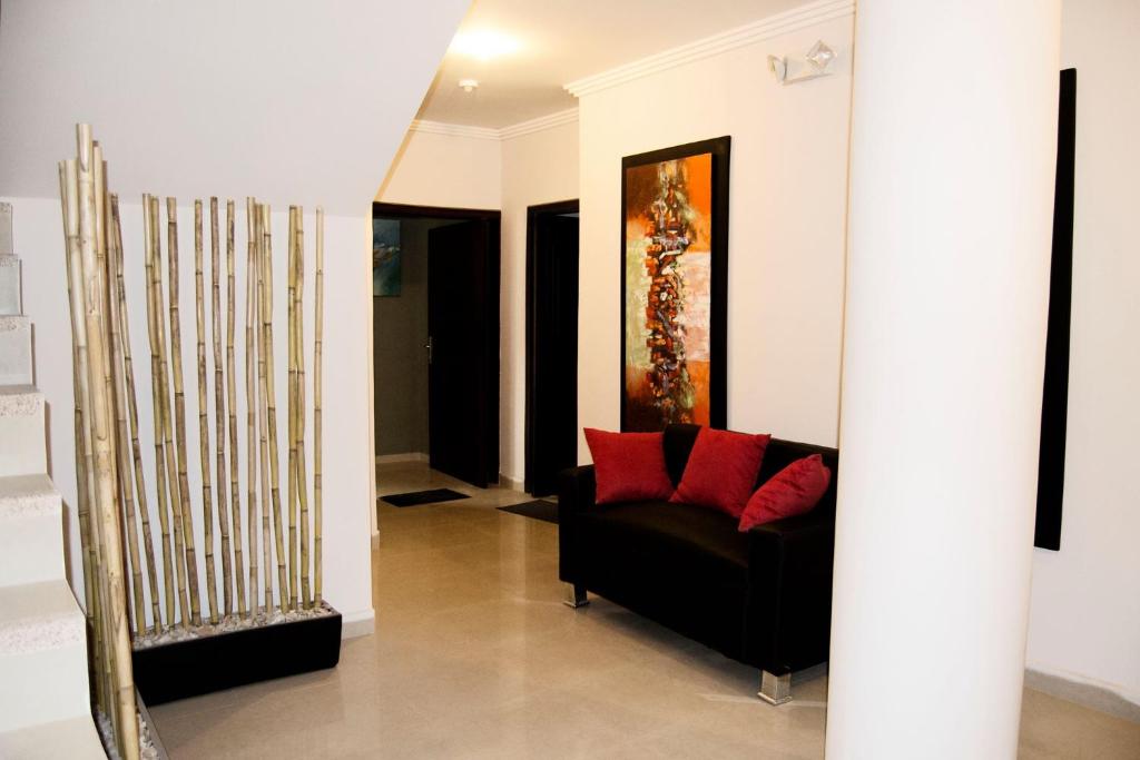 昆卡Hotel Terra Sur Cuenca的客厅配有黑色沙发和红色枕头