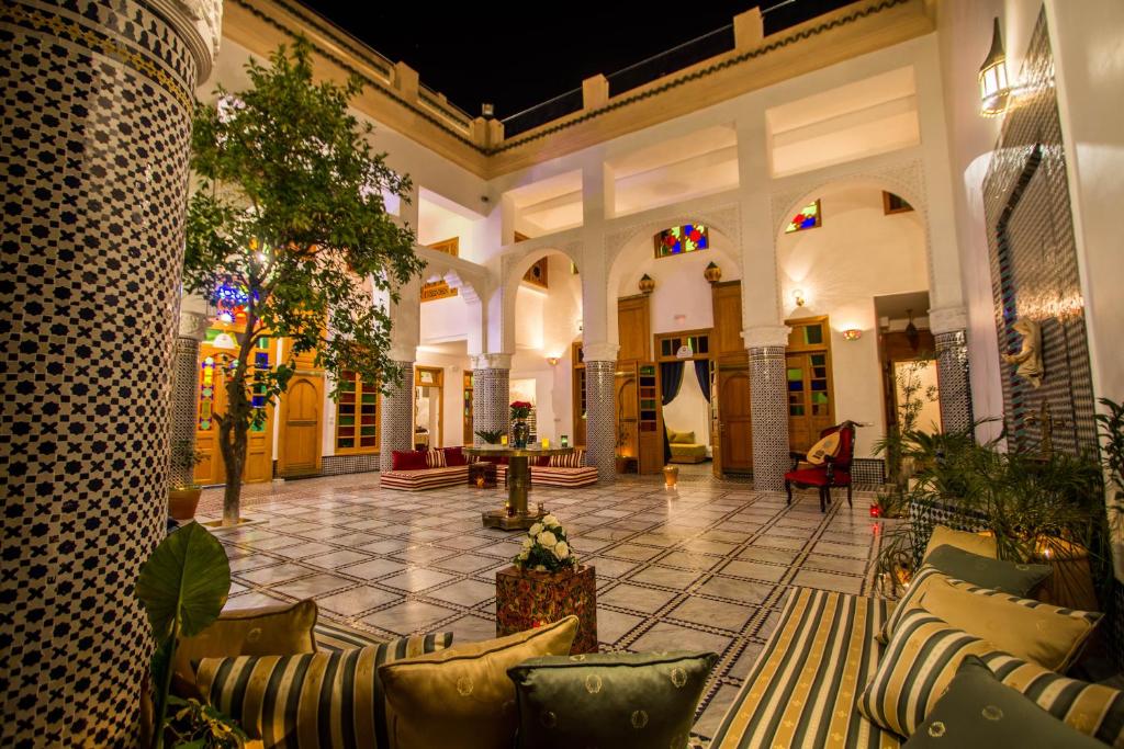 非斯Riad Amor - Suite & Spa的大厅,带有长沙发和树木的建筑