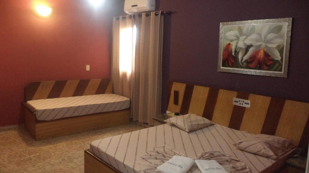 圣贝尔纳多-杜坎普Hotel New Plaza的一间卧室设有两张床,墙上挂着一幅画