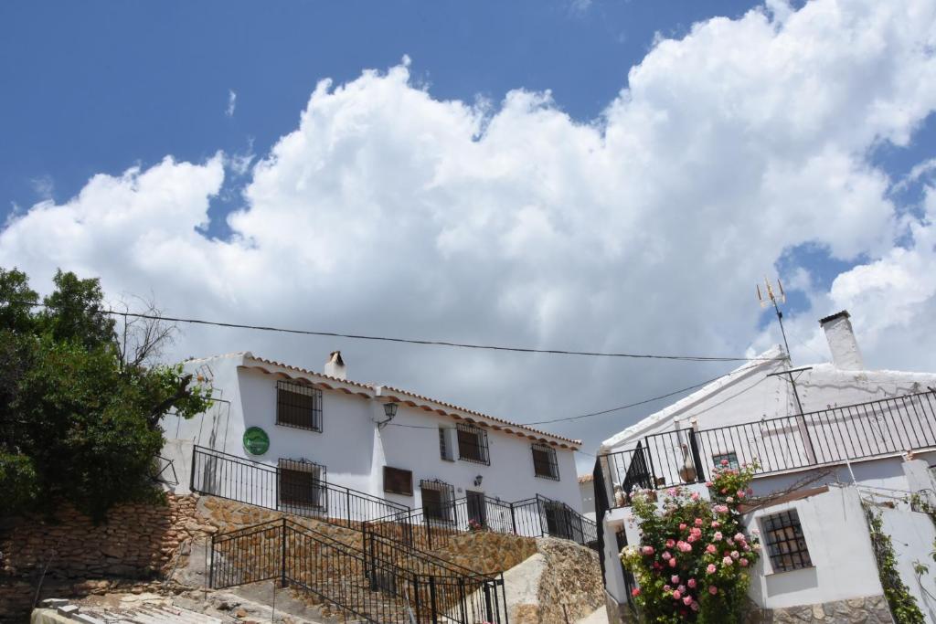 卡斯特里尔Casa Rural El Gandulillo的前面有鲜花的白色建筑