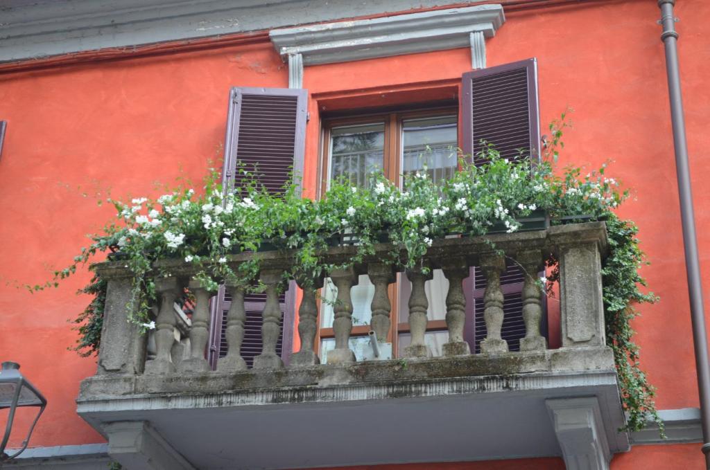 阿尔巴阿尔菲里公寓的红色建筑中带鲜花的阳台