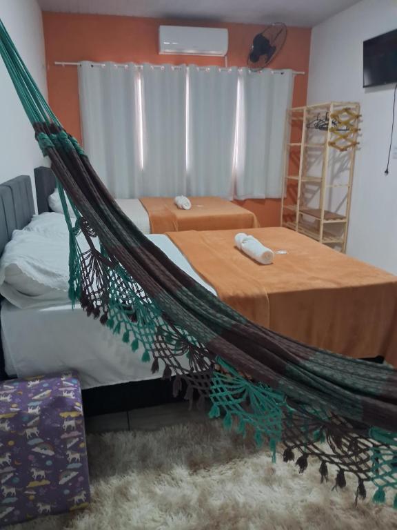 巴雷里尼亚斯Hospedagem Aconchego Do Lar的卧室配有吊床和两张床