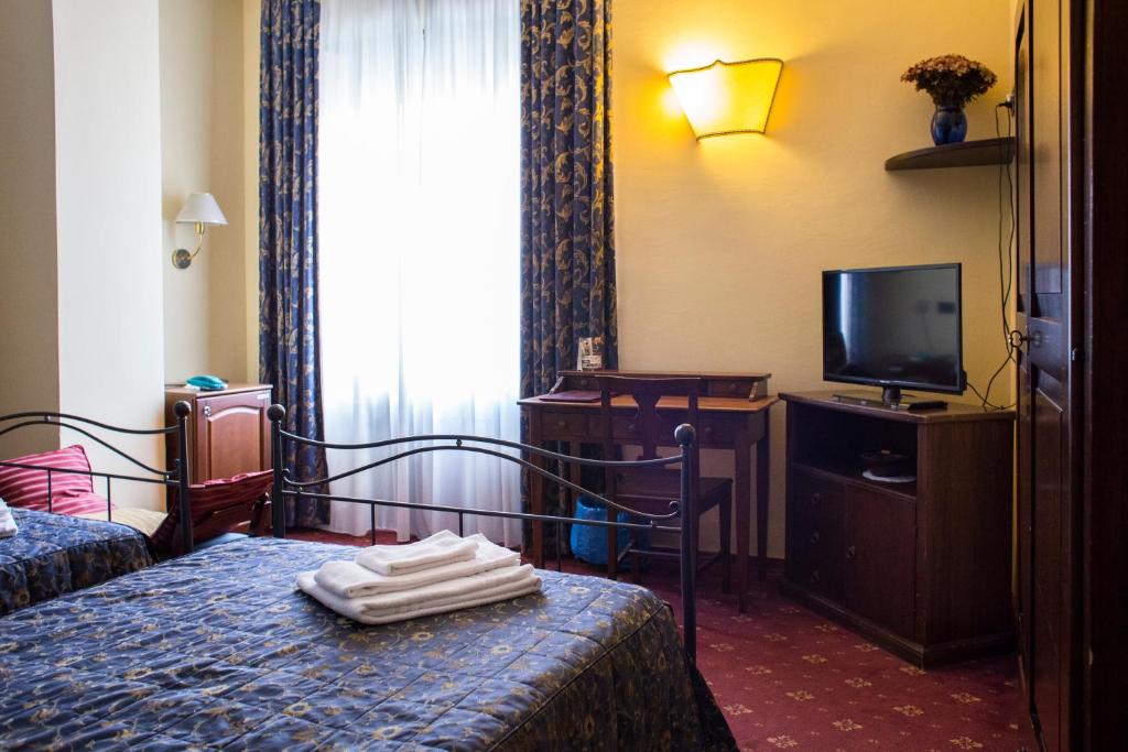 都灵帕科菲拉酒店的酒店客房,配有床和电视