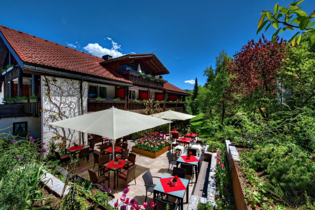 上施陶芬DIANA Naturpark Hotel - mit Oberstaufen Plus Golf的一个带桌子和遮阳伞的户外庭院