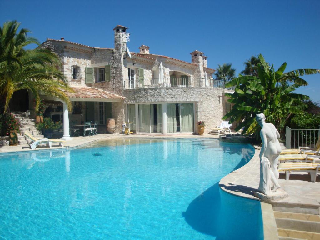 旺斯La Bergerie B&B的一座大房子,在游泳池前设有雕像