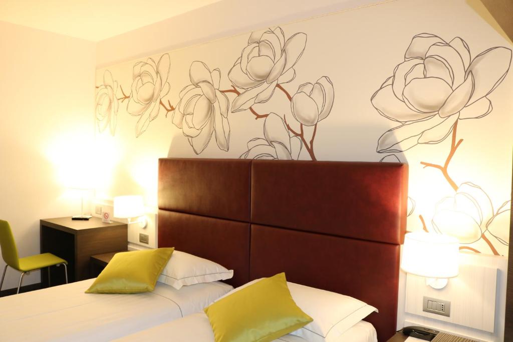 雷吉奥洛纳比拉别墅酒店的卧室配有一张挂着花壁画的床。