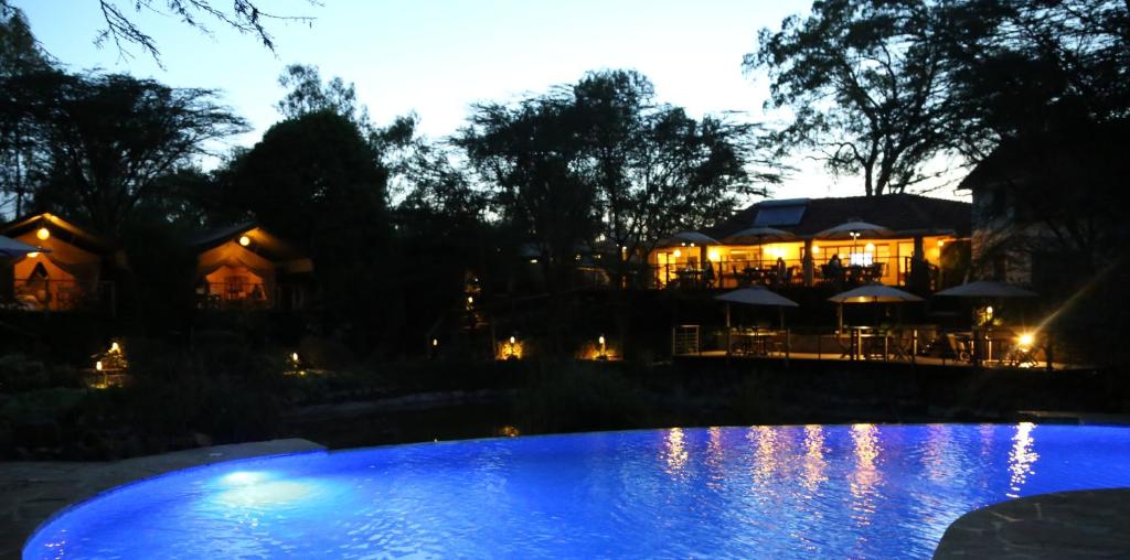 内罗毕牛羚生态帐篷营地的一座灯光的房子,晚上设有游泳池