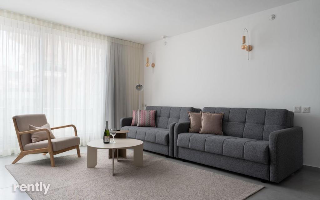 埃拉特Luxury Apartments And Studios At Sea Side By Rently的客厅配有沙发、桌子和椅子