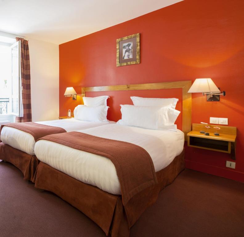 巴黎法兰西埃菲尔酒店的红色墙壁的酒店客房内的两张床