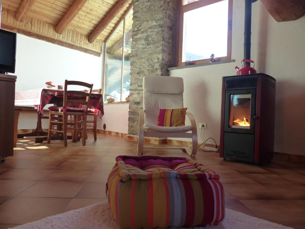 OzeinAppartamenti Grivola的客厅配有燃木炉灶和椅子