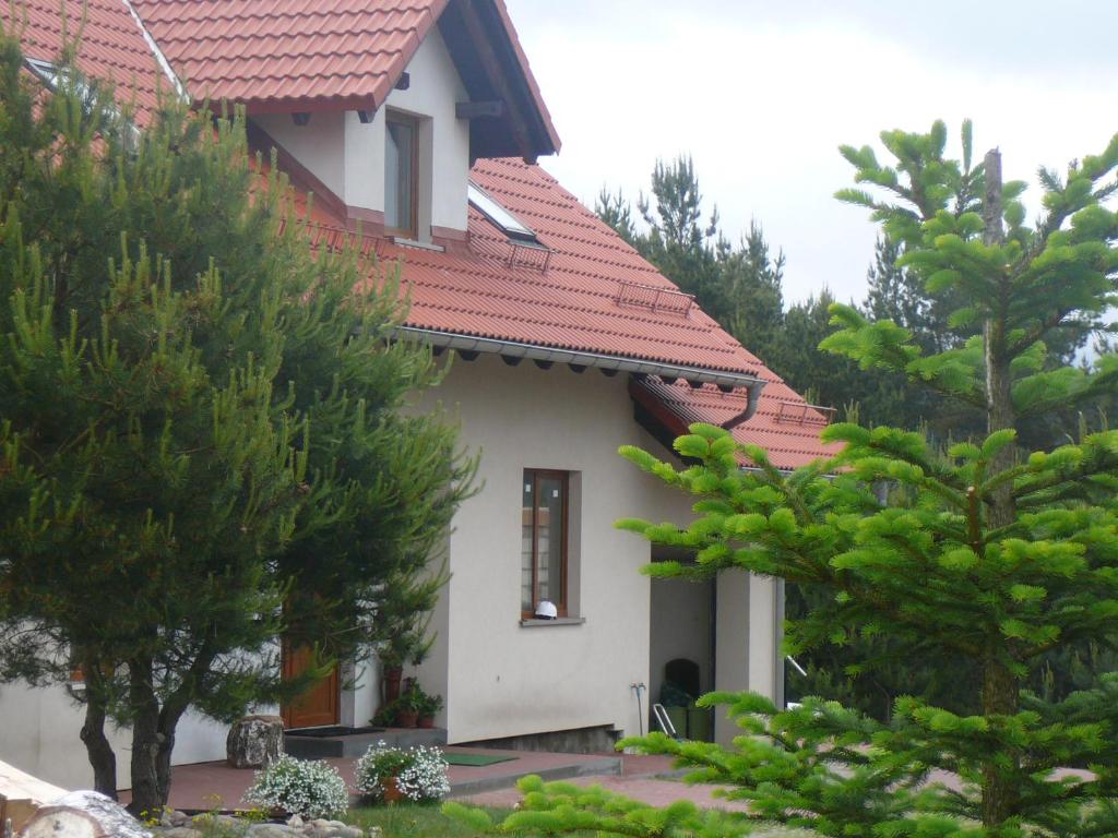 SominyAgroturystyka Sominy Piotr的一座有红色屋顶和一些树木的房子