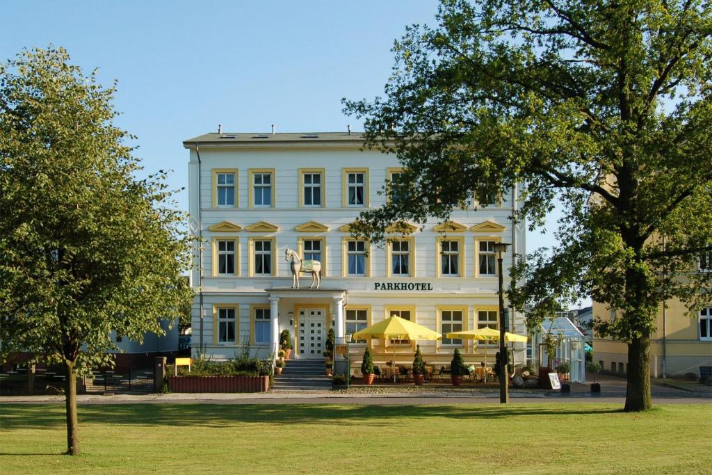 萨斯尼茨德尔马公园酒店的前面有桌子的白色建筑