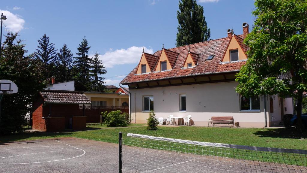 包姚Kisviza Vendégház的前面有篮球场的房子