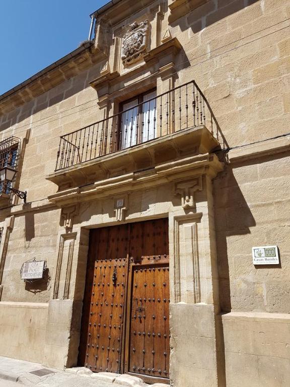 HueteCasa Palacio Conde de Garcinarro的一座带大木门和阳台的建筑